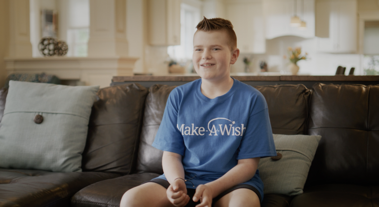 Colby wearing a blue "Make A Wish" t-shirt