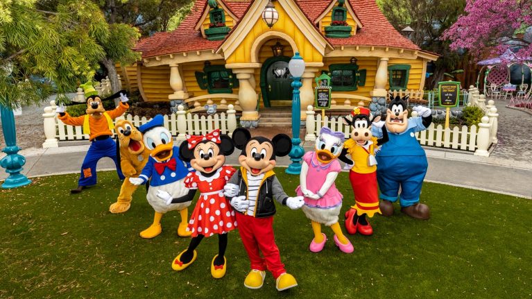 Mickey Mouse, Minnie Mouse, Daisy Duck, Clarabelle, Donald Duck, Pluto, Goofy and Pete posing in front of Mickey's house