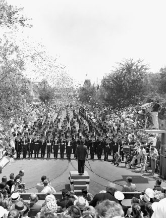 Photo of all-brass band marching down Main Street, U.S.A