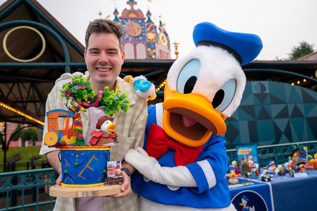 A cast member poses with Donald Duck