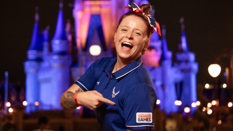2024 Department of Defense Warrior Games athlete Carly smiles in front of Cinderella Castle