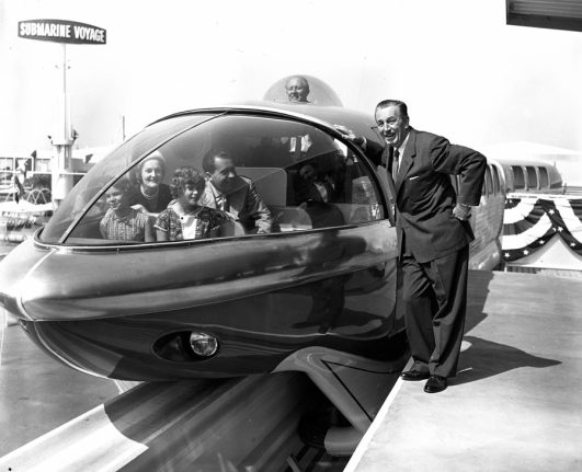 Walt Disney leaning against monorail