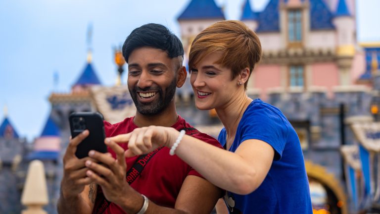 Man and Woman Holding phone at Disneyland Resort