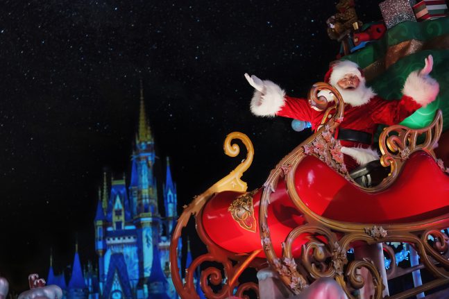 Santa Claus in his sled in front of Cinderella Castle