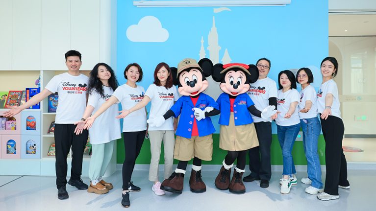 Disney VoluntEARS pose with Mickey and Minnie at a Disney Fun House