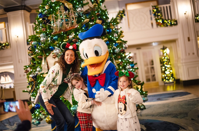 A family poses with Donald Duck inside a Disney resort hotel