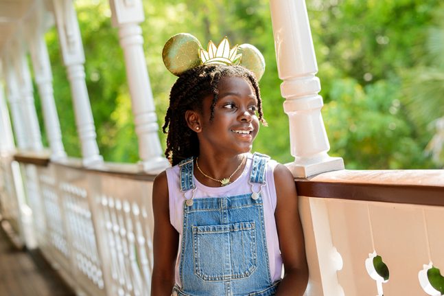 Girl smiling wearing Princess Tiana ears