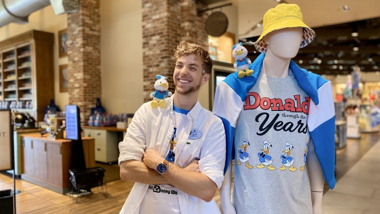 Jeffrey smiles in front of a Donald Duck merchandise display