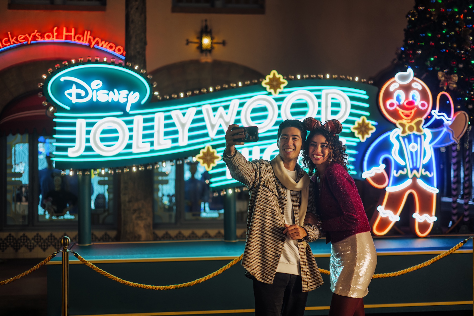 Disney Jollywood Nights sign with Ollie on it and guests taking a photo