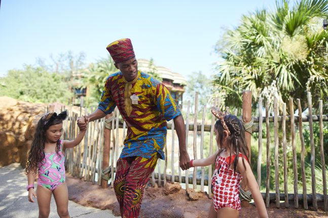 A Cultural Rep at Disney’s Animal Kingdom Lodge  smiles with two guests