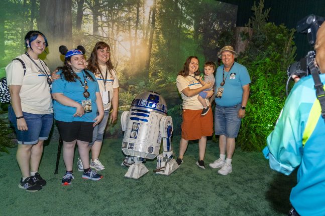 Guests pose for photos in front of a Star Wars backdrop