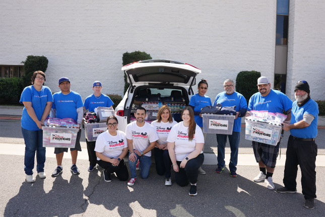 Disney VoluntEARS pose with Love Anaheim volunteers holding care kits