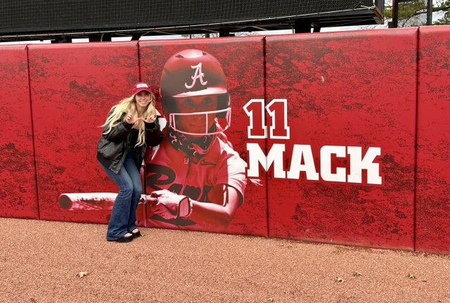 Alexis poses in front of her softball banner