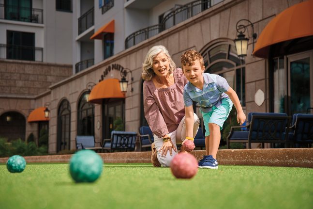 Guests play bocce ball on the lawn at Disney's Riviera Resort