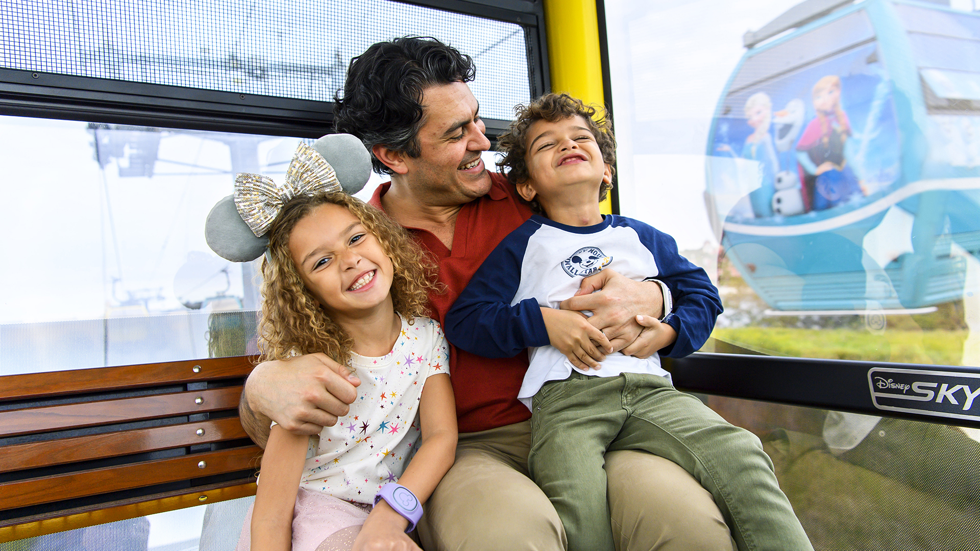 A family laughs together onboard the Disney Skyliner