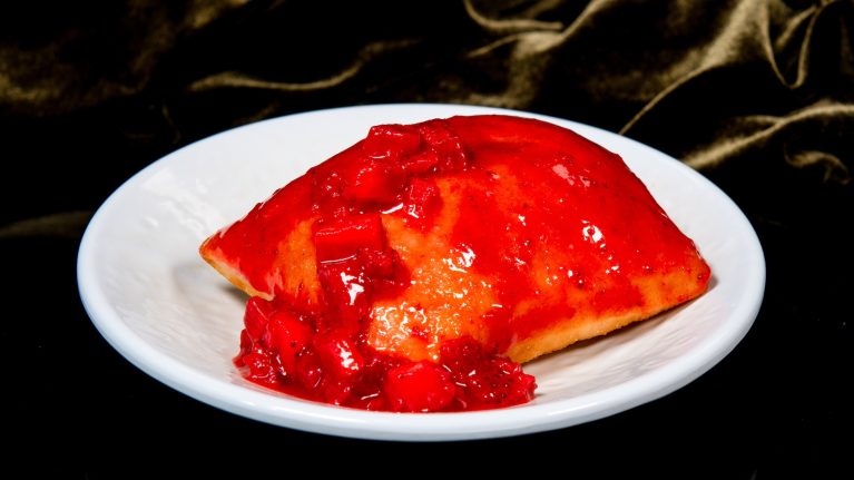 Specialty strawberry pie-filled beignet with strawberry cream filling and topped with strawberry glaze at Tiana’s Palace