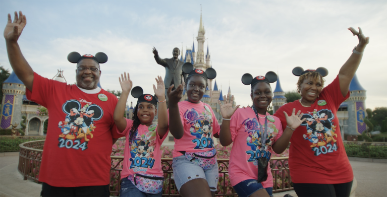 Jackie and her family smile in front of Cinderella Castle