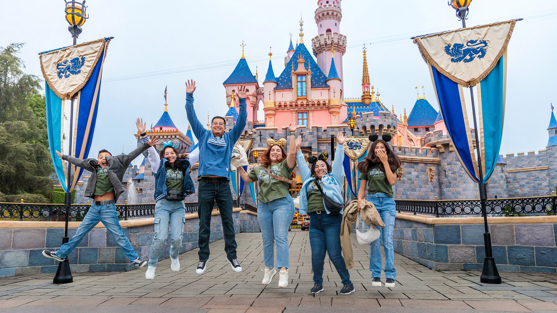 David and his family jump in front of Sleeping Beauty Castle at Disneyland Park