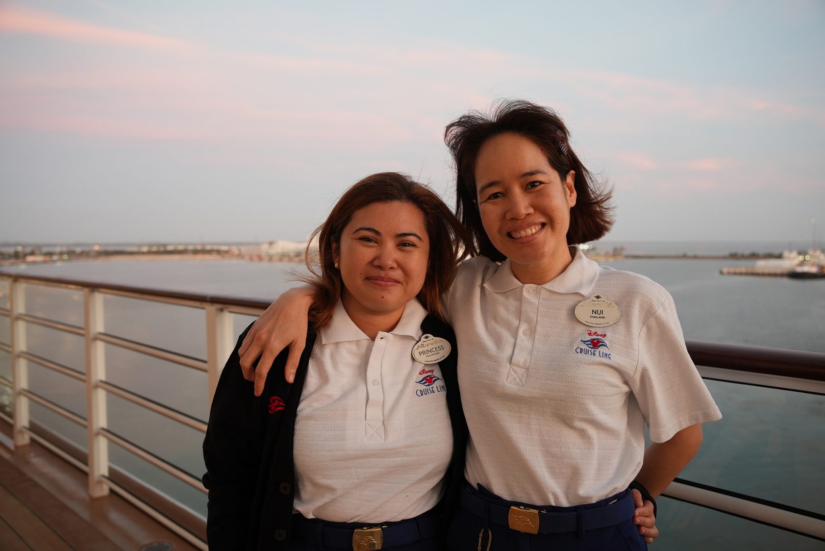 Two crew members pose onboard the Disney Treasure