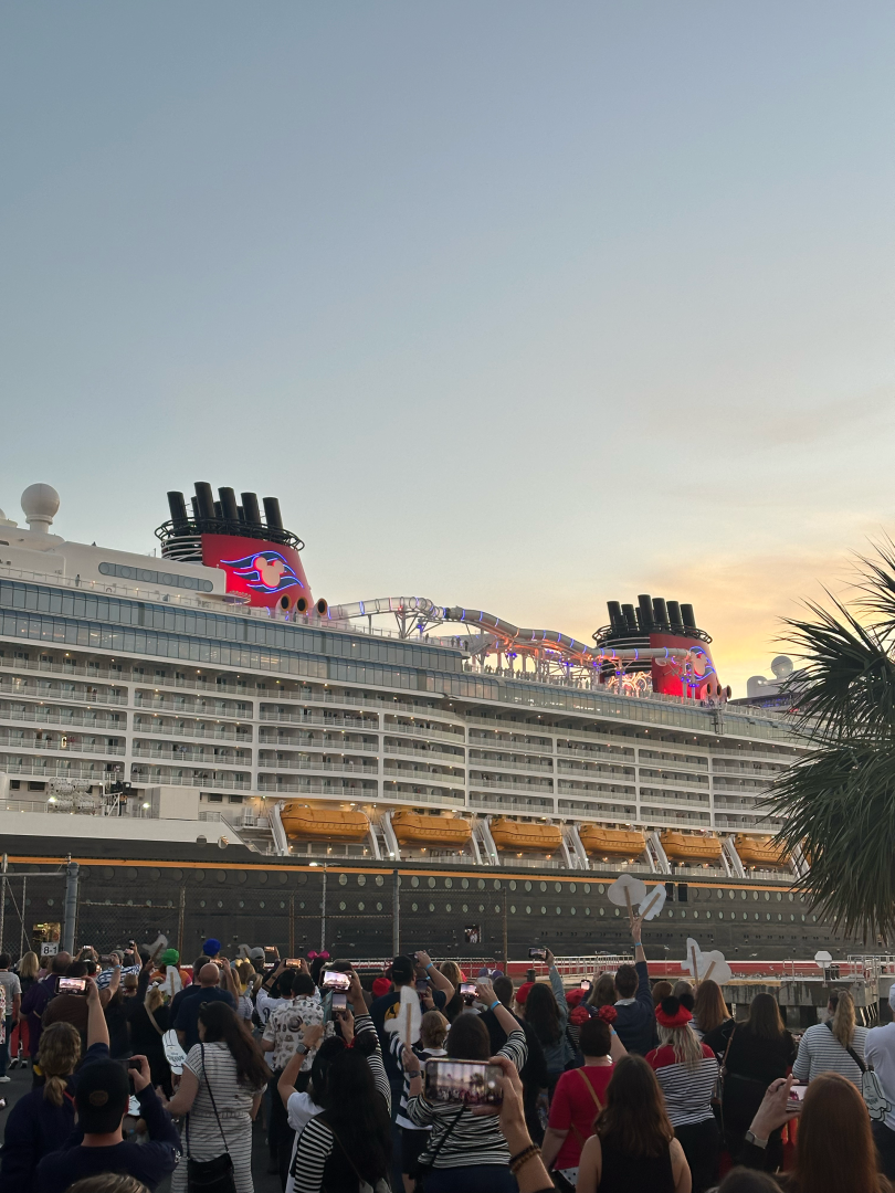 Crew members greet the Disney Treasure