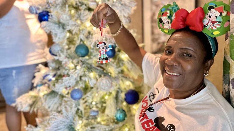 Disney VoluntEAR hangs ornament -- Disney Brings Holiday Joy to Veteran Families at Orlando Fisher House