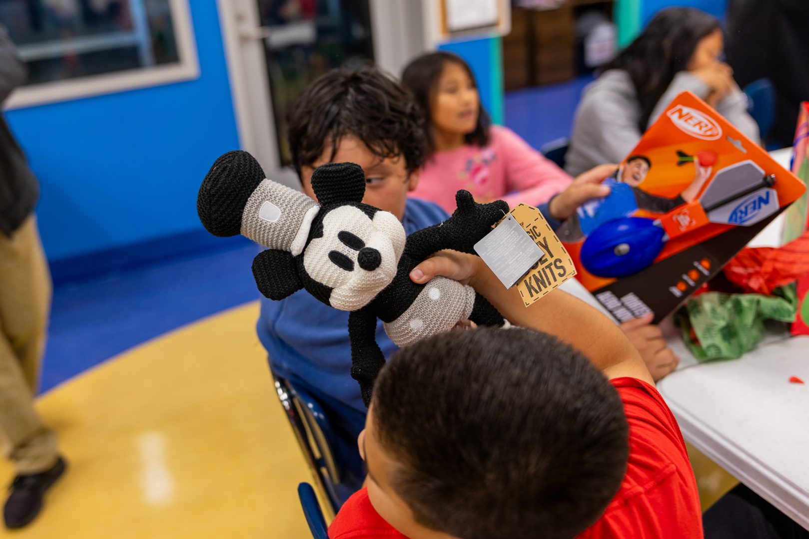 A child holds up a Mickey plush