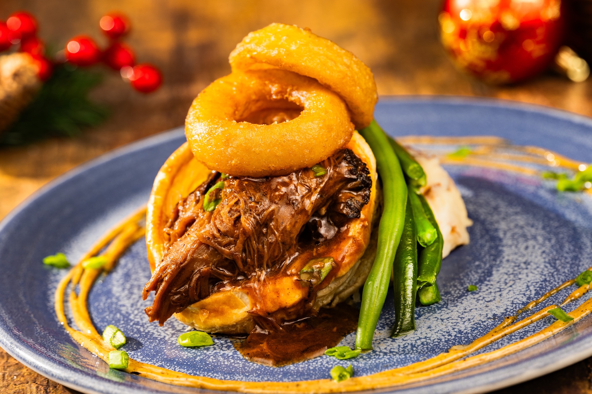 Holiday Beef Pot Roast: Served in a puff pastry crust with mashed potatoes, beer-battered onion rings, and black garlic-truffle aïoli (New) 