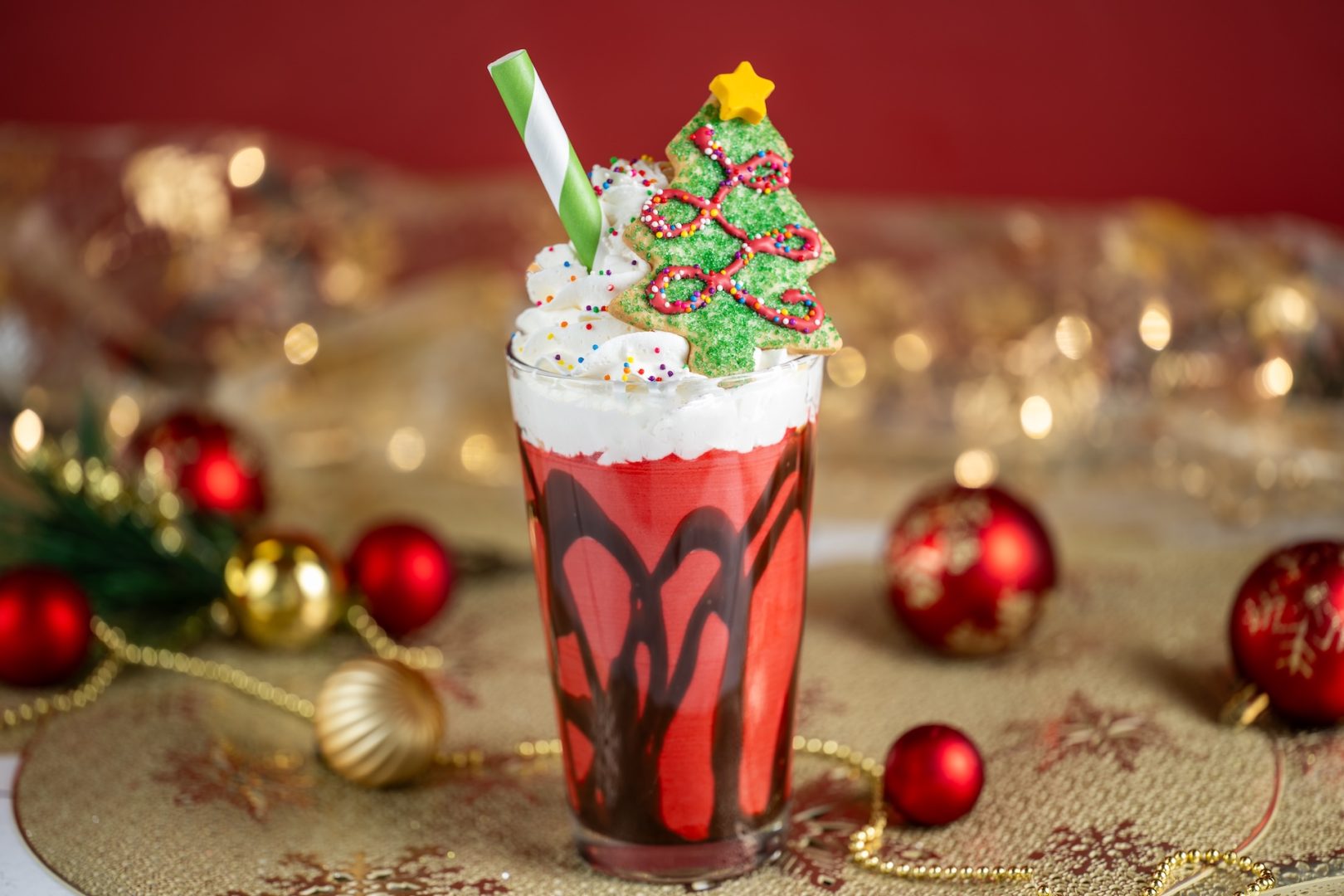 Red Velvet Holiday Milk Shake: Red velvet milk shake swirled with chocolate sauce and topped with whipped cream, rainbow sprinkles, and a holiday tree sugar cookie