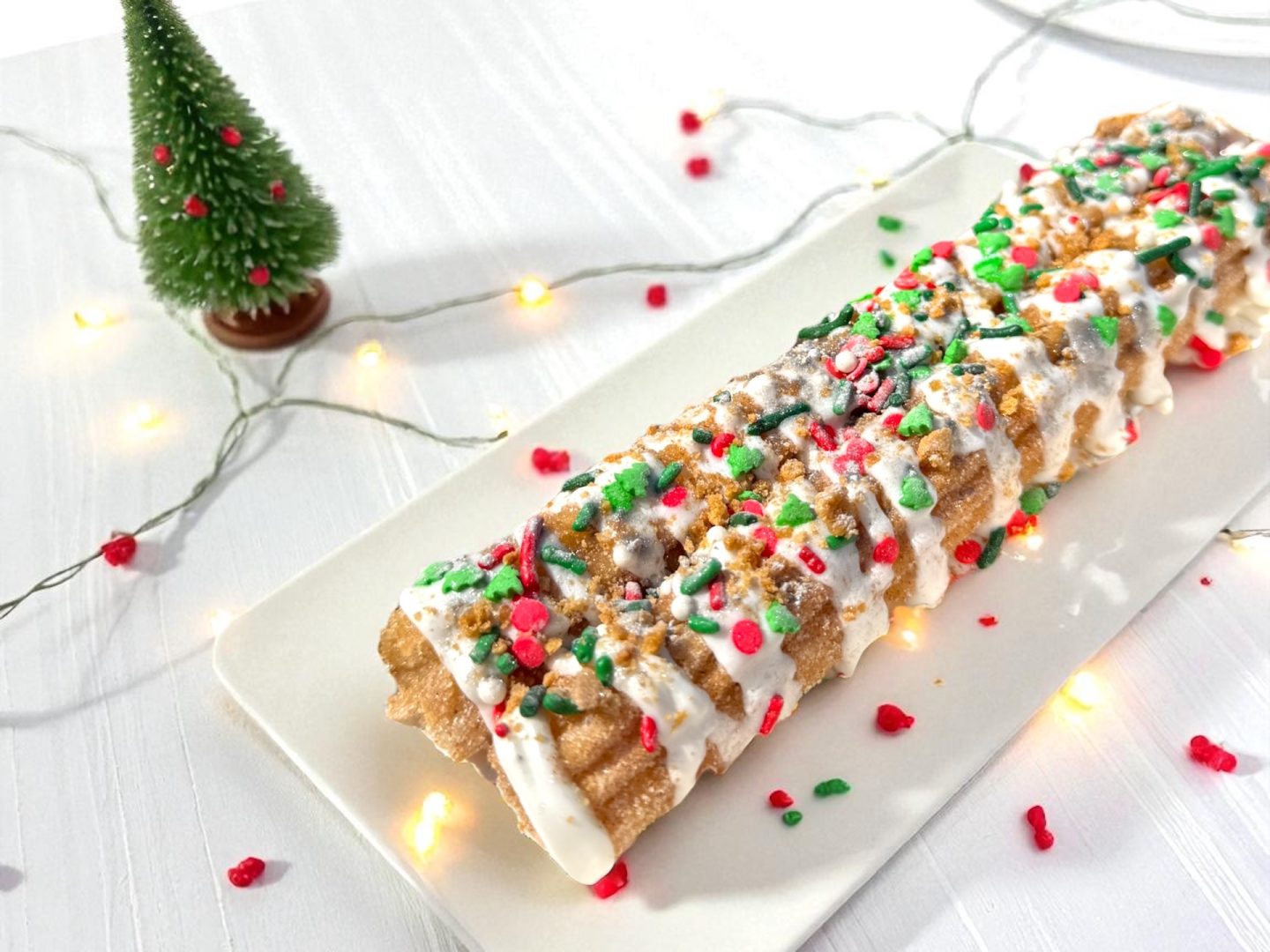 Gingerbread Churro: A churro rolled in gingerbread sugar, drizzled with buttercream frosting topped with crushed gingerbread cookie crumbs and a spritz of edible glitter (New)