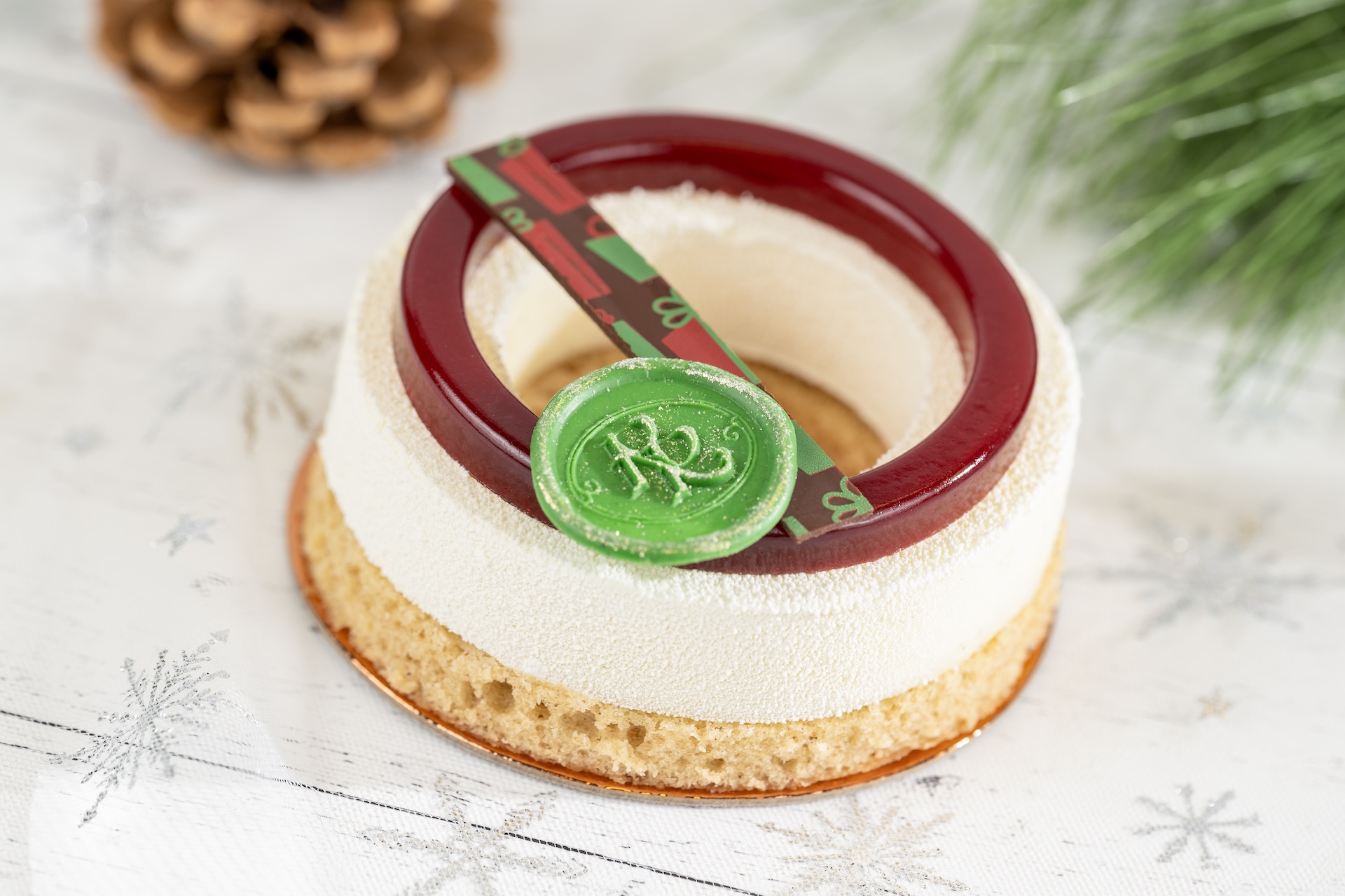 Eggnog tart featuring a red ring and green decorative element on a snowy background.
