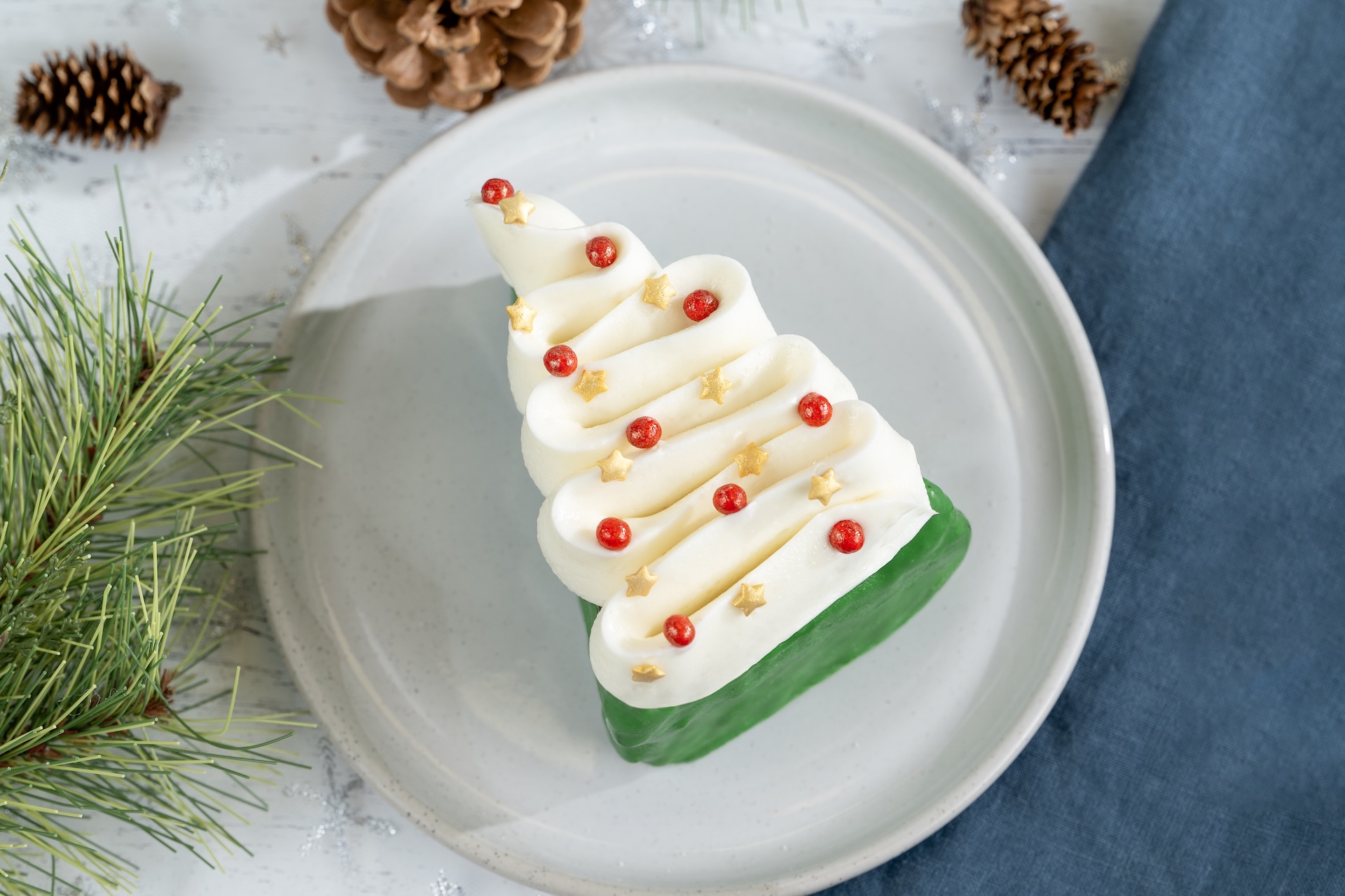 Decorative gingerbread cake shaped like a Christmas tree with festive toppings.