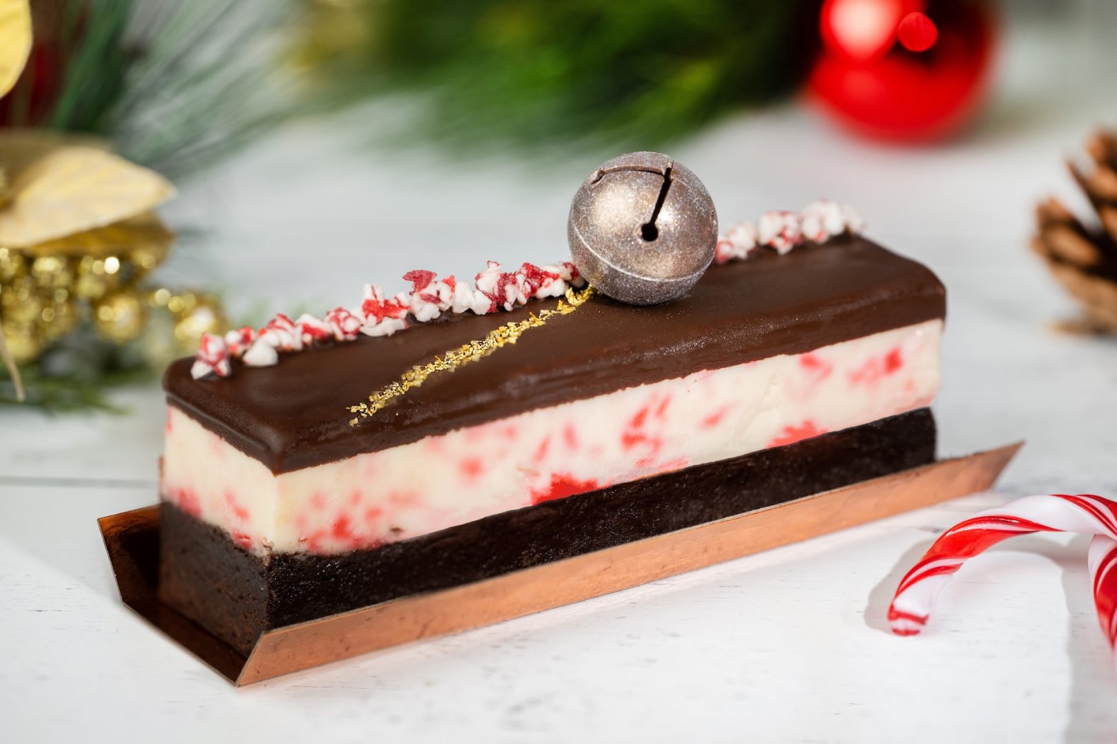Peppermint brownie dessert topped with a bell and festive decorations.