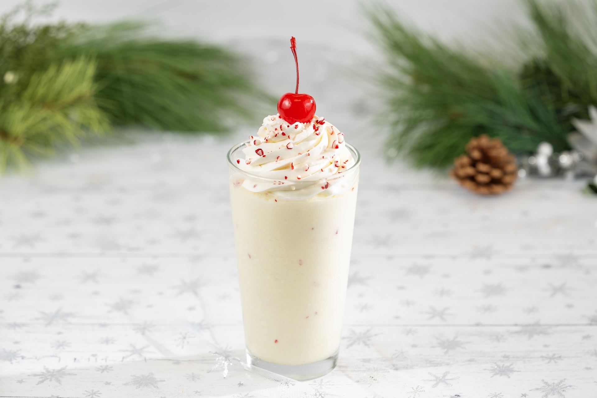A peppermint shake topped with whipped cream and a cherry.