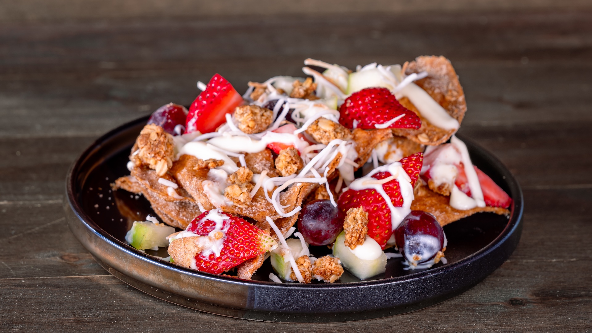Buñuelos Biónico: Fried tortilla chips coated in cinnamon and sugar, loaded with fresh fruit, toasted coconut, and sweetened condensed banana milk