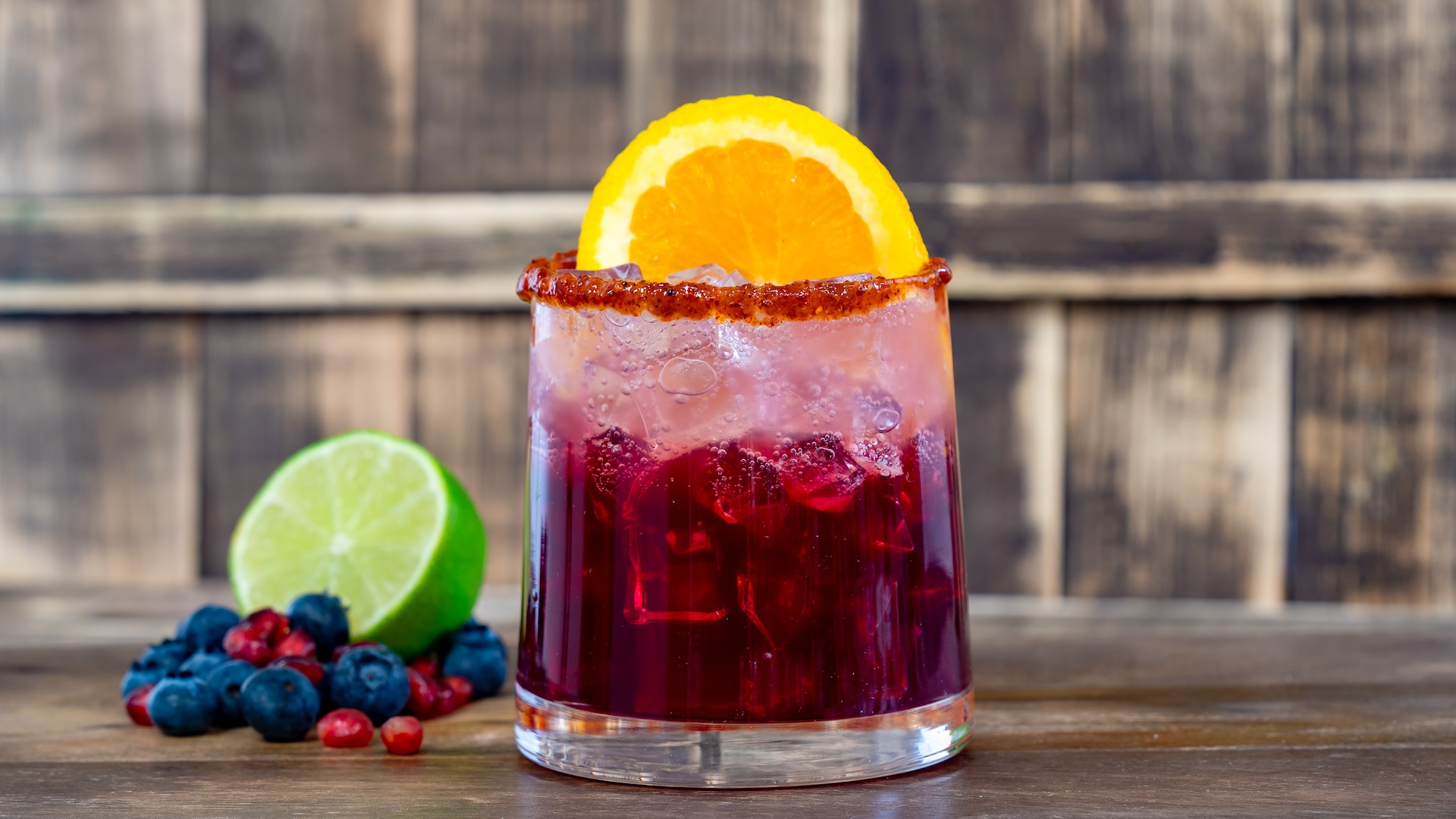 Berry Pomegranate Paloma: Tequila, blueberry purée, lime, cranberry and pomegranate juices, and agave syrup topped with Minute Maid Aguas Fresca and garnished with an orange wheel and a chile-lime rim