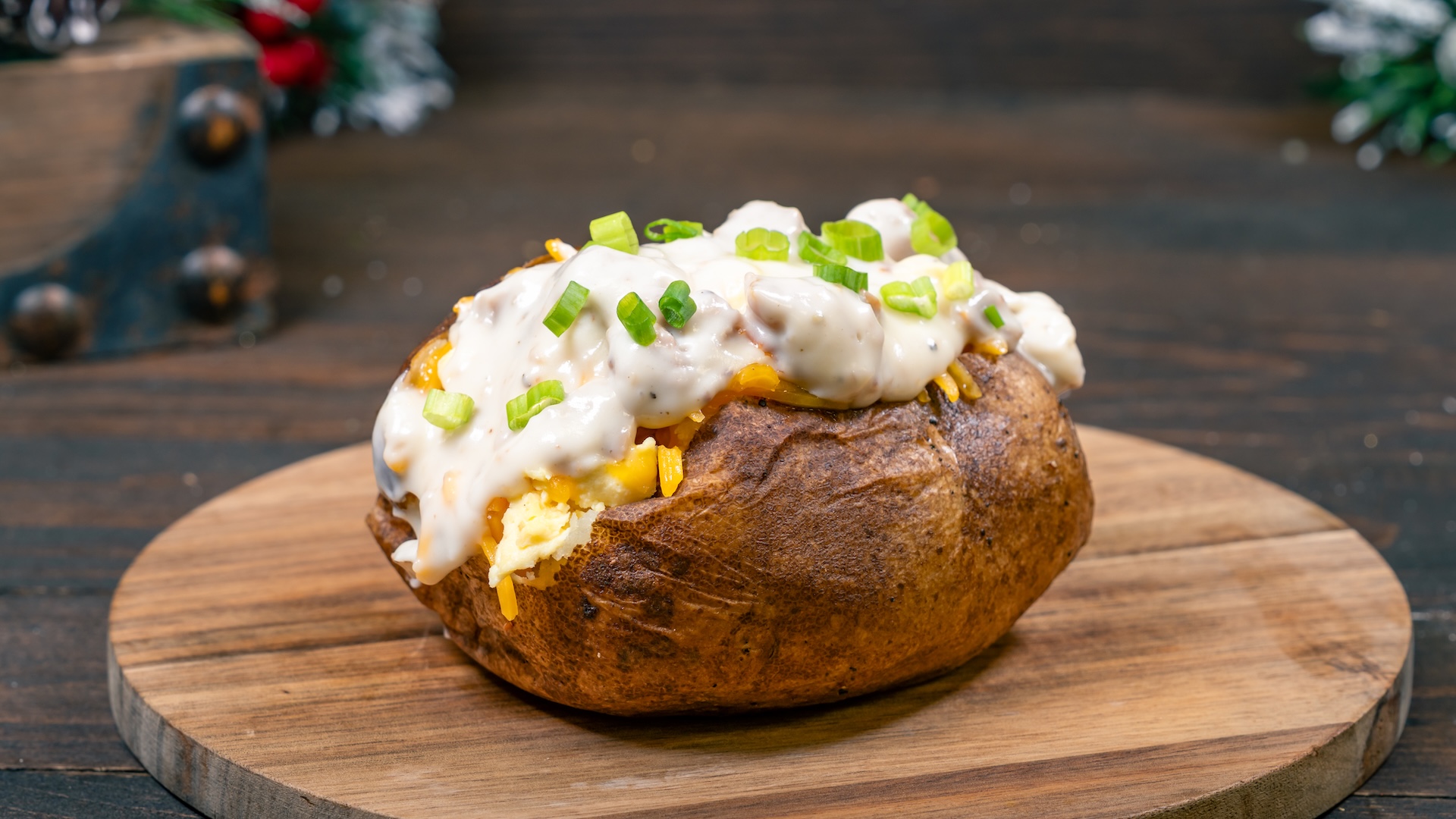 Santa Breakfast Potato: Scrambled eggs, shredded cheese, country sausage gravy, and green onions