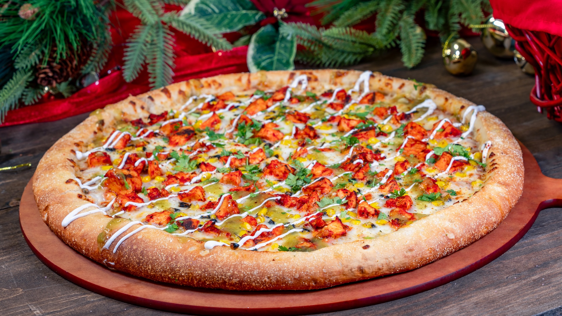 Al-ien Pastor Pizza: Spiced red sauce, mozzarella cheese, roasted corn, and al pastor-marinated chicken garnished with crema and tomatillo sauce drizzle, and cilantro 