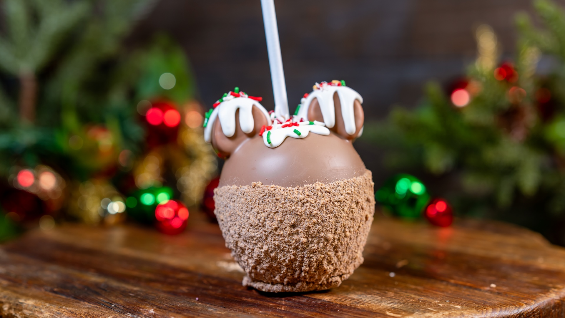 Hot Chocolate Caramel Apple: Green apple dipped in caramel with two marshmallow ears, dipped in milk and white chocolate, decorated with graham cracker and hot chocolate powder mix with white chocolate drips, and embellished with holiday sprinkles and peppermint crush (Only available at Candy Palace and Candy Kitchen, Trolley Treats, Bing Bong’s Sweet Stuff, and Disney Wonderful World of Sweets) (New) 