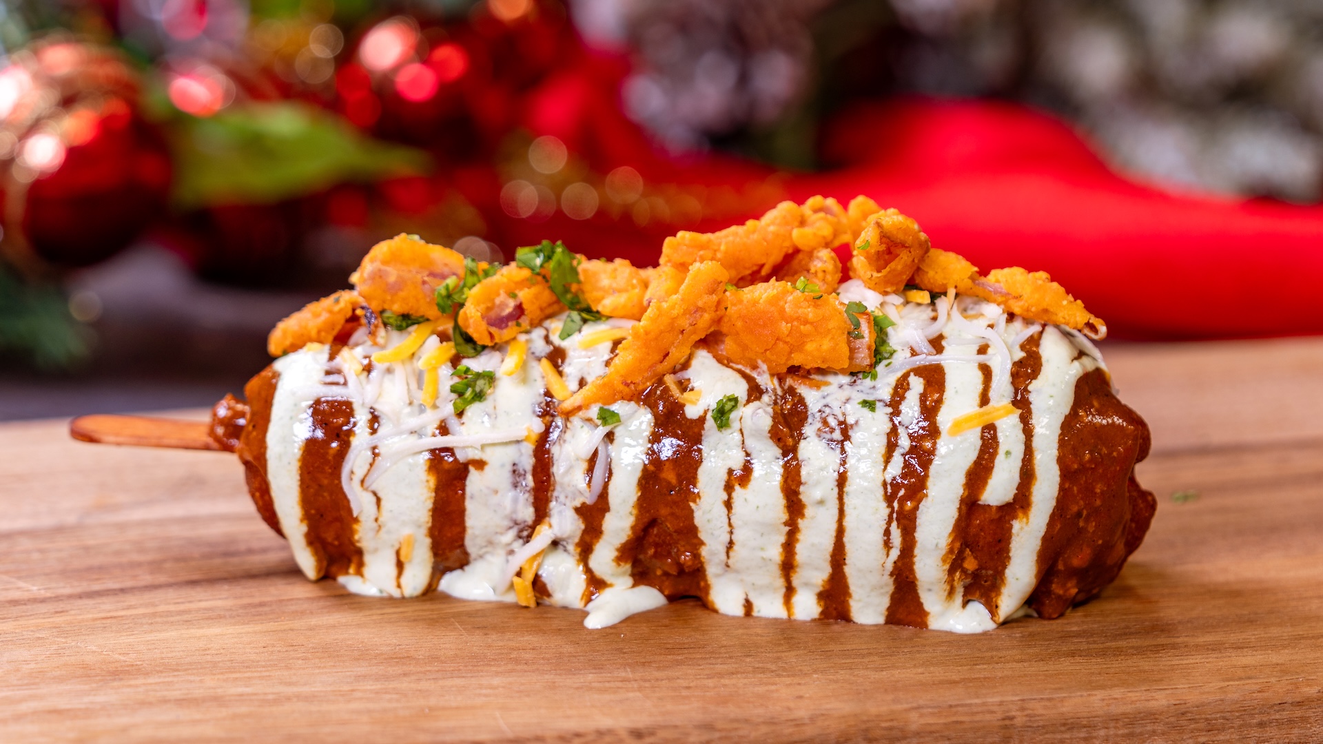 Chili Cheese Corn Dog: Classic corn dog topped with spicy chili, jalapeño-cilantro crema, cheddar cheese, and crispy onions served with choice of Cuties Mandarin Orange or potato chips 