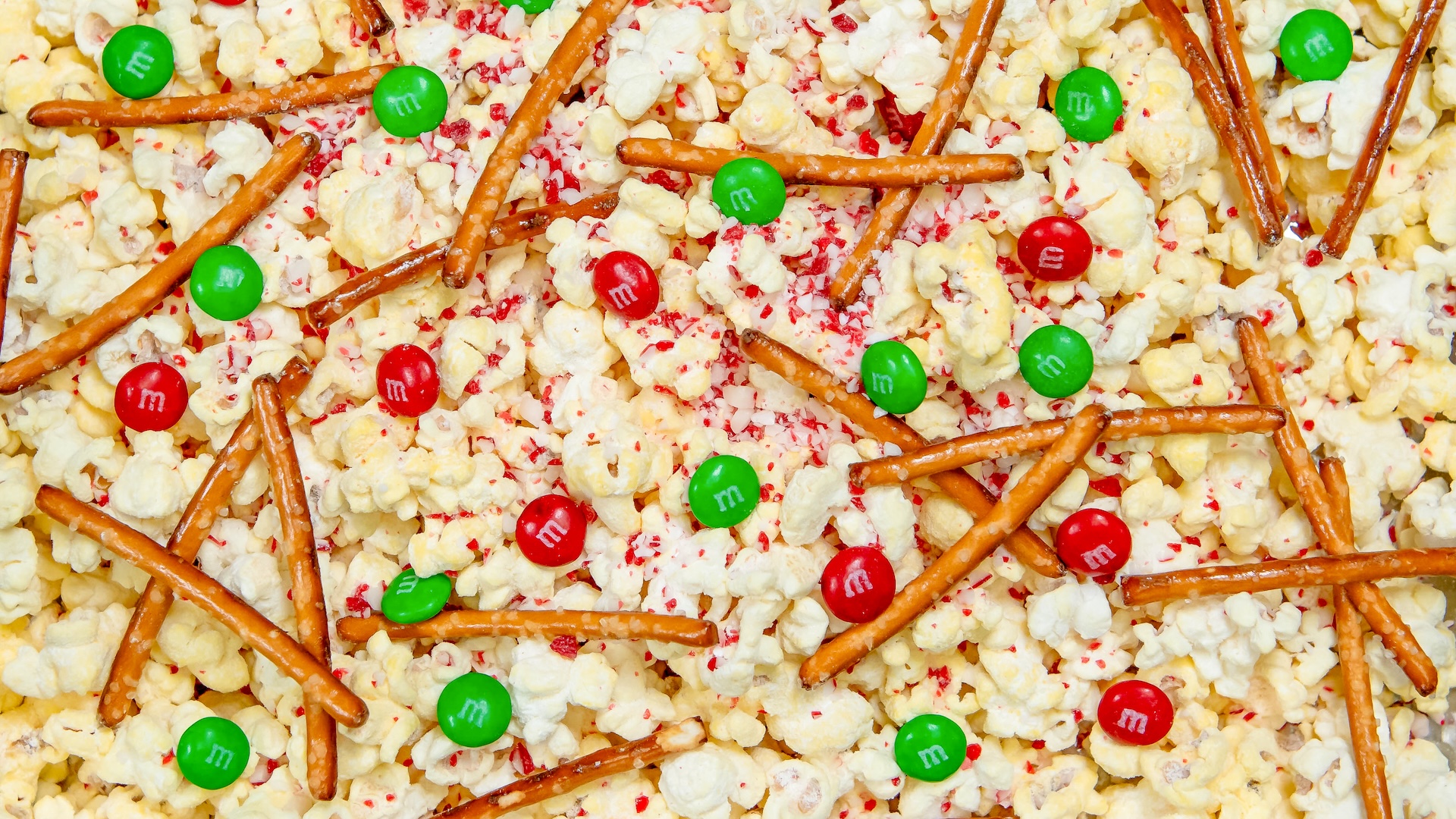 Holiday Popcorn: White chocolate-dusted butter popcorn with a mix of M&M'S Milk Chocolate Candies, pretzel sticks, and crushed peppermint 