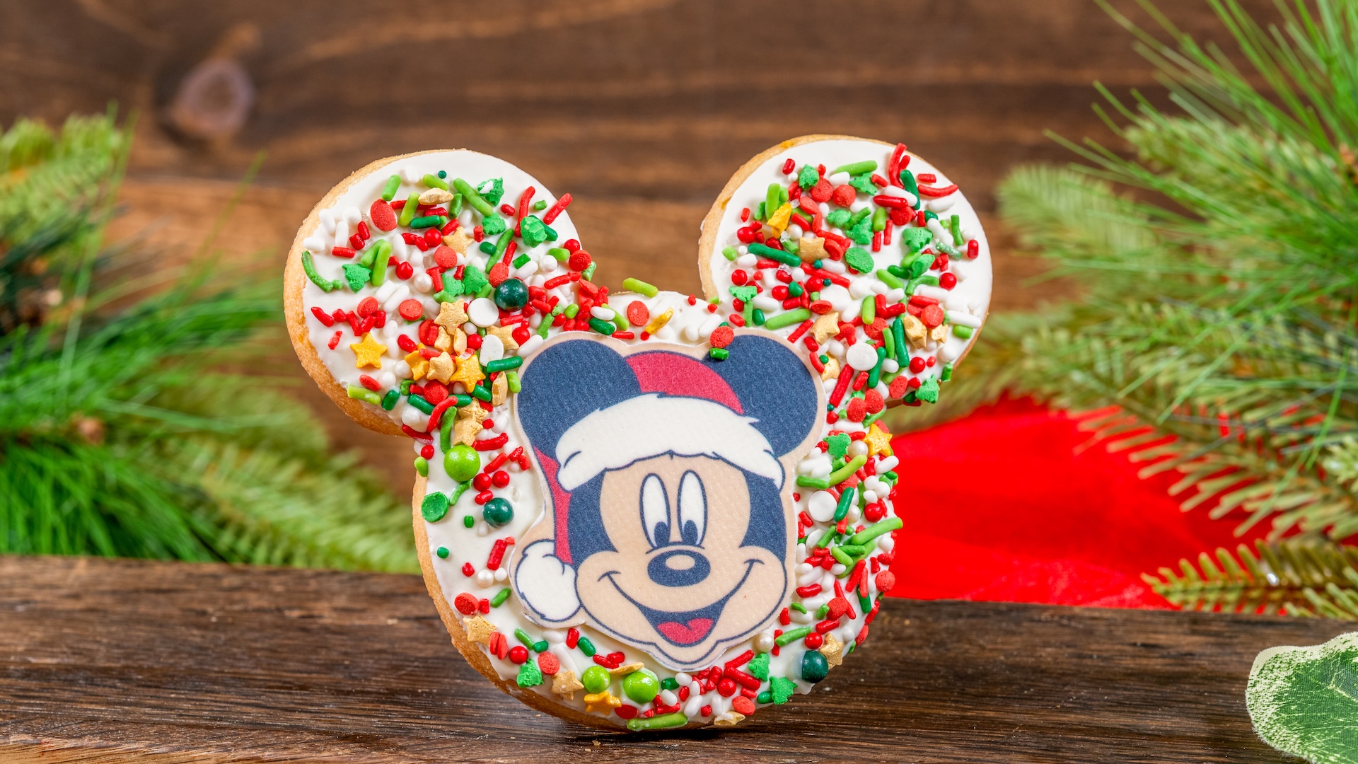 Mickey-shaped Holiday Cookie: Shortbread cookie dipped in white chocolate with holiday sprinkles, and a chocolate Mickey decoration 