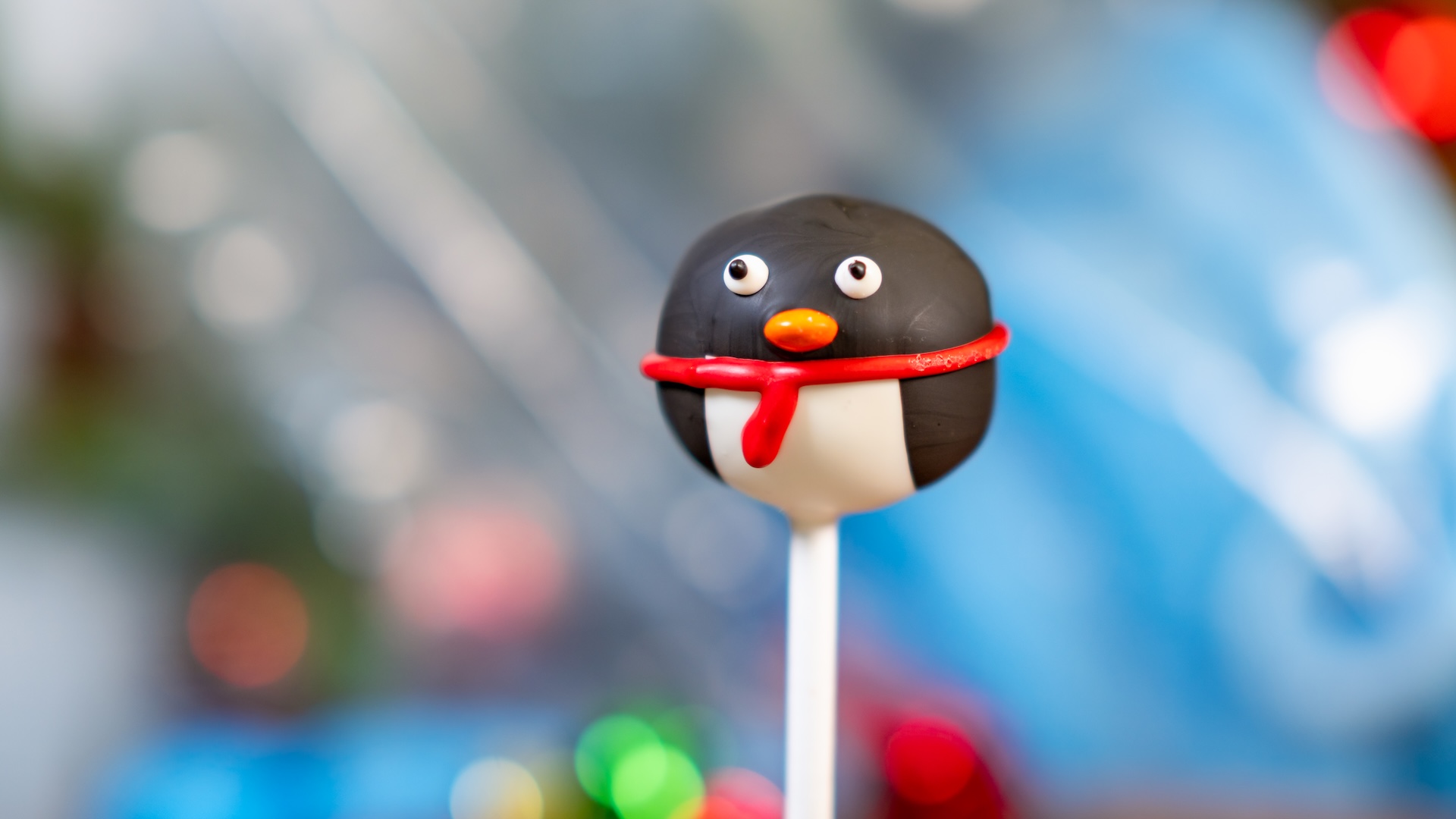 Penguin Cake Pop: Chocolate cake pop dipped in peppermint-flavored white chocolate, decorated with black-colored dark chocolate, an orange mini M&M’S Milk Chocolate Candy, and red-colored white chocolate (New) 