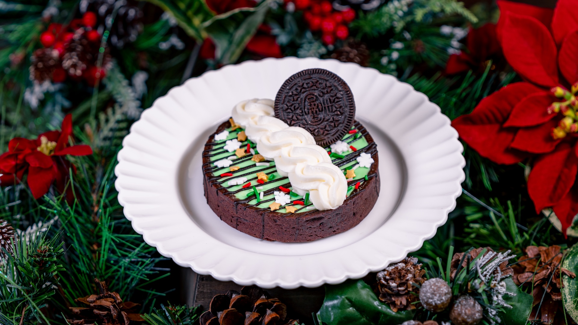 Peppermint Chocolate Tart: Chocolate tart shell filled with chocolate ganache and mint marshmallow, finished with chocolate lines, whipped topping, sprinkles, and a chocolate-filled cookie 