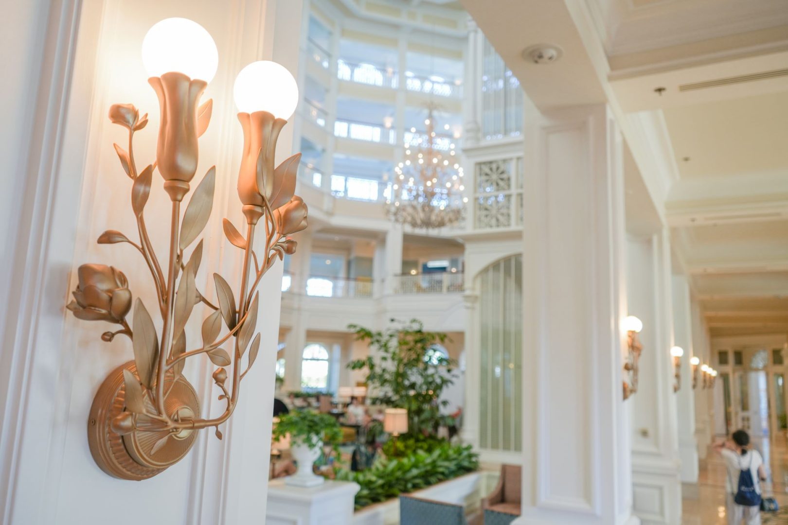 Elegant lobby with floral wall sconces and lush greenery at the Grand Floridian.
