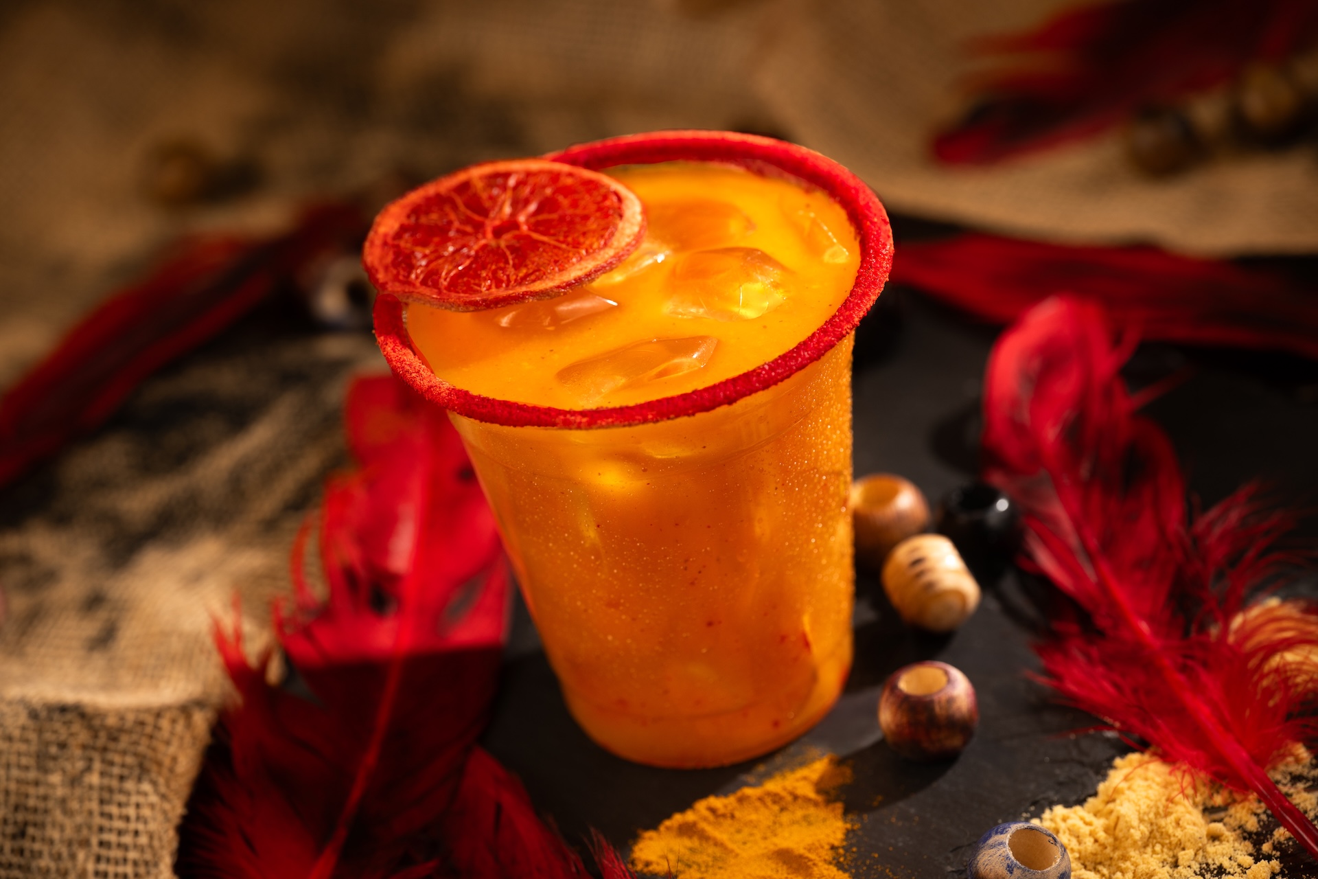 Trader&rsquo;s Tailwind: Captain Morgan Original Spiced Rum, Bols Triple Sec Liqueur, mango pur&eacute;e, Minute Maid Orange Juice, chamoy, and ginger beer with a chili-lime-rimmed glass garnished with a dehydrated blood orange wheel 