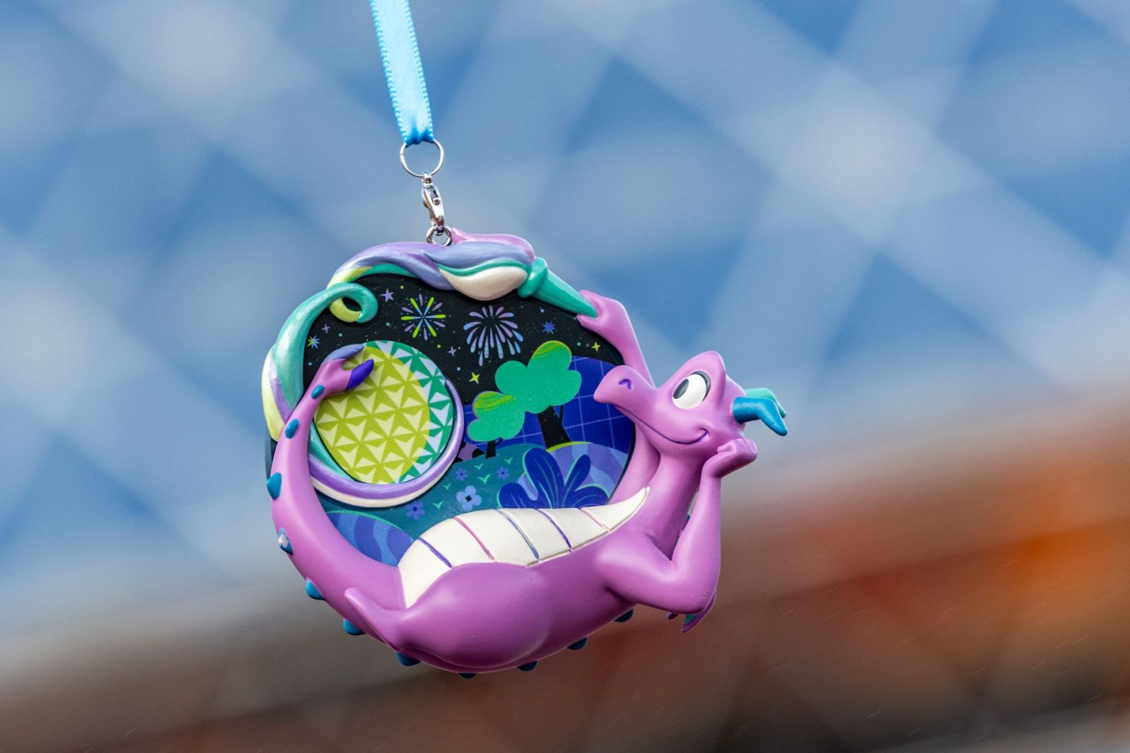 Purple dragon ornament with vibrant designs against a blue background.