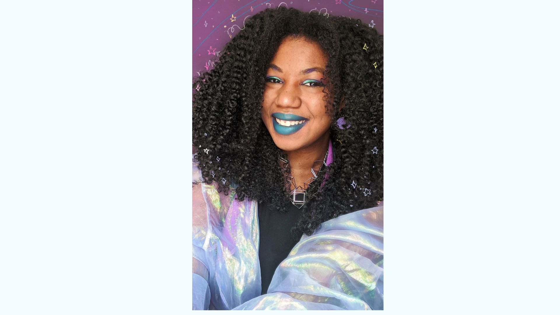 Smiling person with curly hair, colorful makeup, and an iridescent outfit.