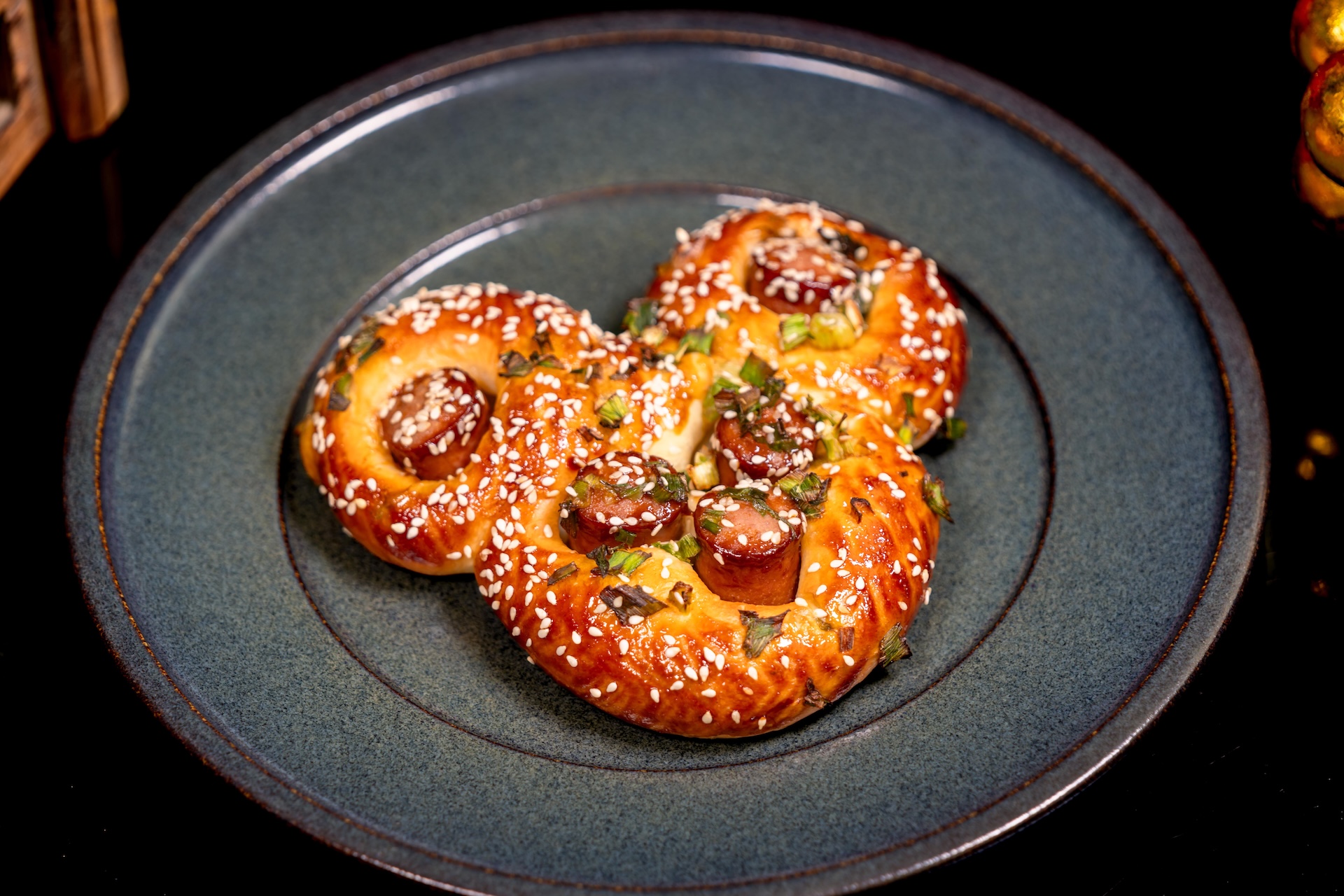 Mickey-Shaped Hot Dog Bun: Classic milk bread with hot dogs, hoisin glaze, parmesan, green onion, and sesame seeds