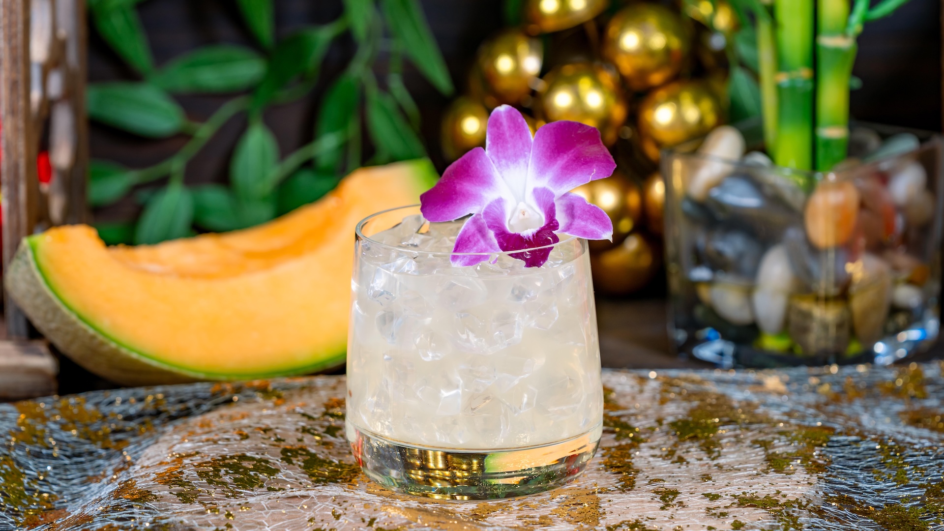 Yuja-Melon Cocktail: Gin, Lillet Blanc, yuja pur&eacute;e, and rock melon syrup garnished with a purple orchid (New)