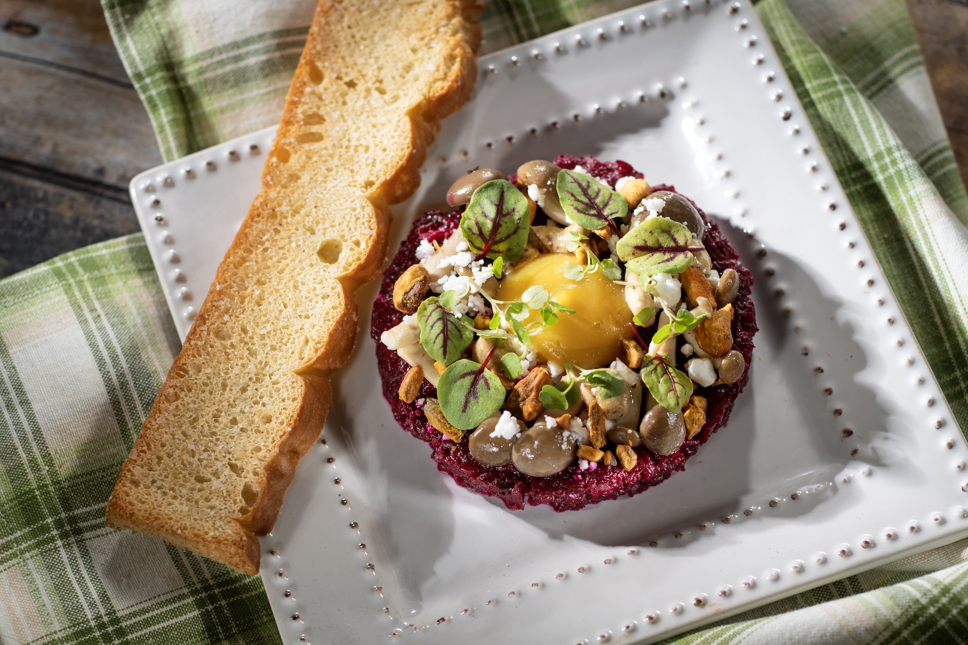 Citrus-braised Beet Tartare with golden beet &ldquo;egg yolk,&rdquo; mustard vinaigrette, pickled mustard seeds, pickled mushrooms, spiced pistachios, and &ldquo;feta&rdquo; snow (Plant-based)